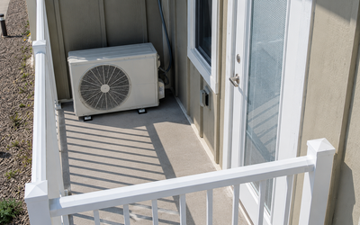 Air-to-air heat pump outdoor unit installed on a residential balcony