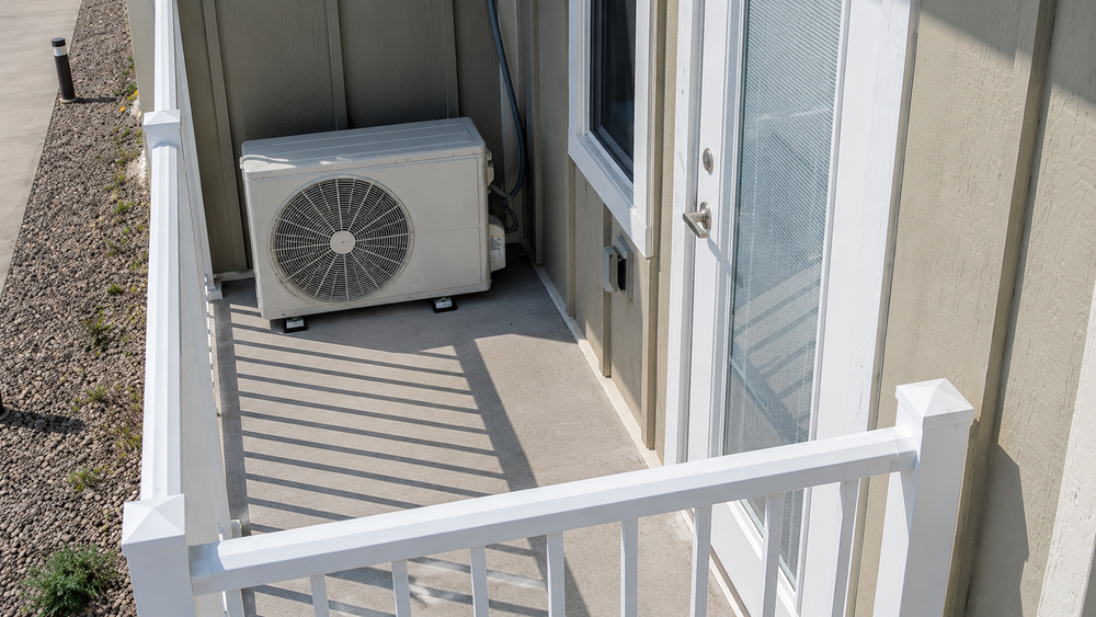 Air-to-air heat pump outdoor unit installed on a residential balcony
